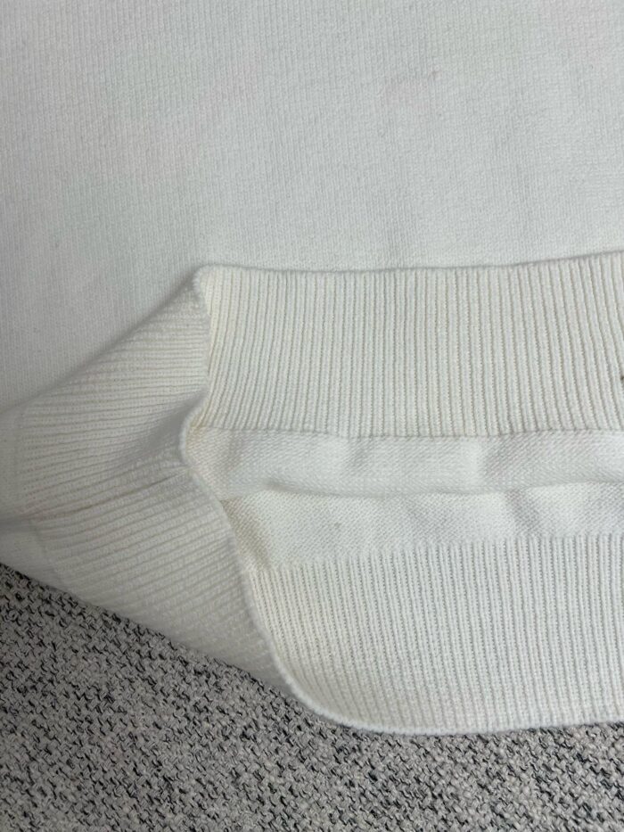 Maglione bianco con polsino a costine, morbido e casual, perfetto per un look comodo.
