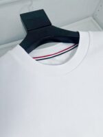 Maglietta bianca casual con collo classico e dettaglio a strisce rosse e blu.
