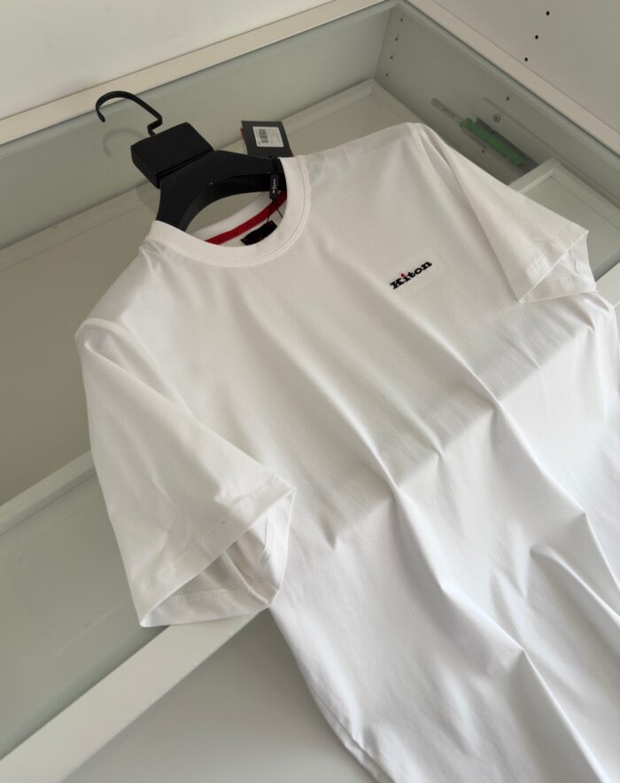 Maglietta bianca minimalista con logo sul petto e colletto rosso, stile moderno e versatile.