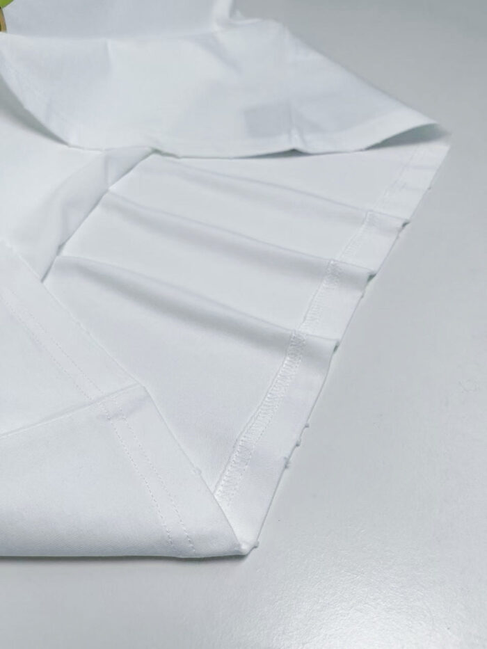 Tessuto bianco impeccabile con cuciture precise, ideale per abiti eleganti e professionali.
