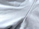 Tessuto bianco leggero con pieghe eleganti, ideale per moda e decorazione raffinata.