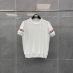 Maglietta bianca con maniche corte a righe rosse, stile sportivo e look casual elegante.