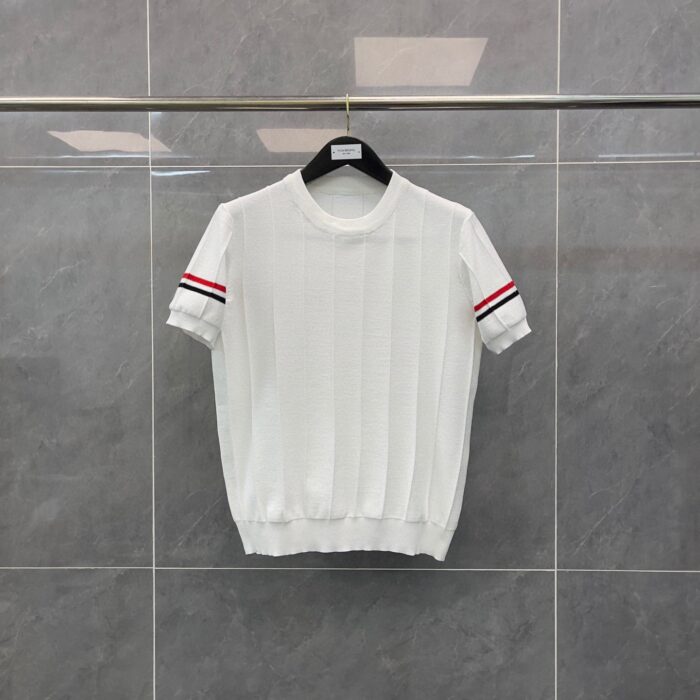 Maglietta bianca con maniche corte a righe rosse, stile sportivo e look casual elegante.