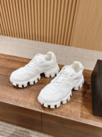 Scarpe sneakers bianche trendy con suola spessa su superficie in legno, stile moderno e casual.