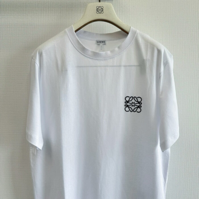 T-shirt bianca casual con piccolo logo nero, semplice ed elegante, ideale per ogni occasione.