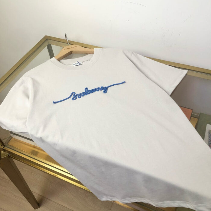 T-shirt bianca con ricamo blu in stile casual e moderno, perfetta per ogni occasione.