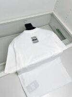 Maglietta bianca minimalista con logo min sul retro, stile casual e moderno.