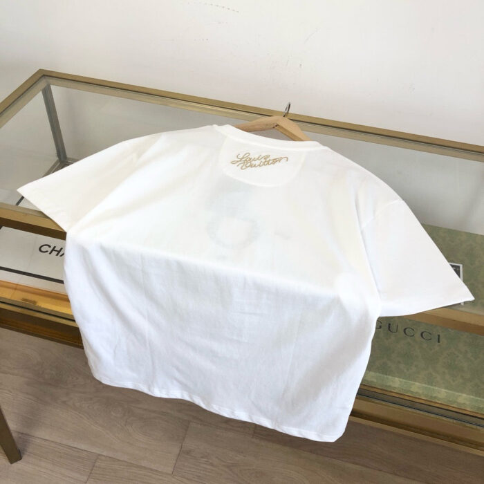 Maglietta bianca di lusso su tavolo vetrina con logo discreto e dettagli eleganti.