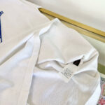 Maglietta bianca casual con dettaglio interno e etichetta, tessuto morbido e maniche corte.