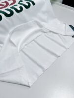 Maglietta bianca con grafica verde e rossa, stile casual, moderna e alla moda.