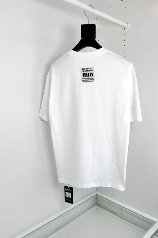 T-shirt bianca minimalista con etichetta MIA, vestibilità elegante, ideale per uno stile moderno e versatile.