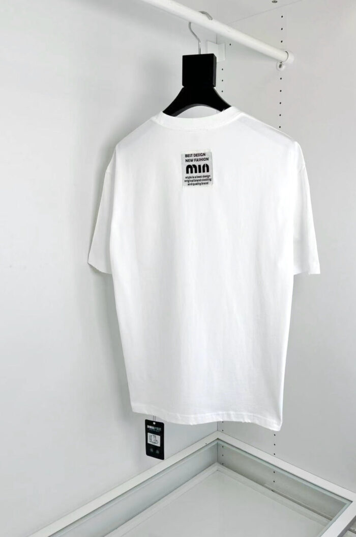 T-shirt bianca minimalista con etichetta MIA, vestibilità elegante, ideale per uno stile moderno e versatile.