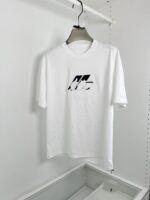 Maglietta bianca minimalista con logo nero astratto, stile urbano, semplice e versatile.