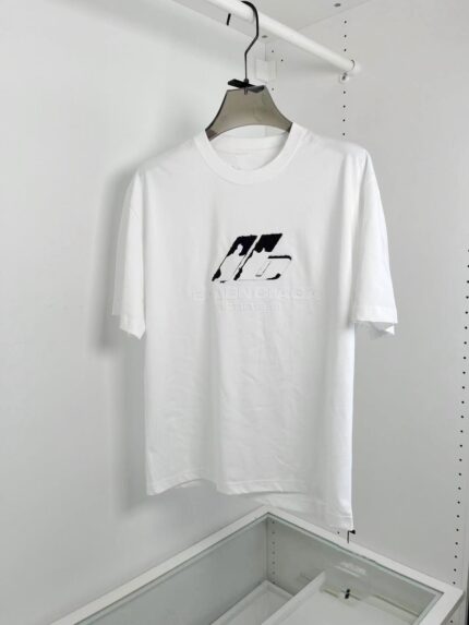 Maglietta bianca minimalista con logo nero astratto, stile urbano, semplice e versatile.