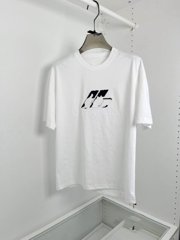 Maglietta bianca minimalista con logo nero astratto, stile urbano, semplice e versatile.
