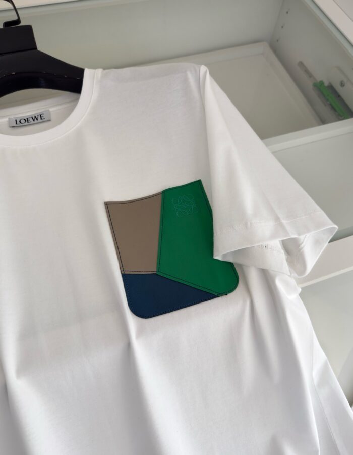 T-shirt bianco con tasca colorata patchwork, stile moderno e casual.