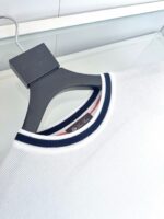 Maglione bianco con colletto navy e dettaglio rosso, stile moderno e chic.