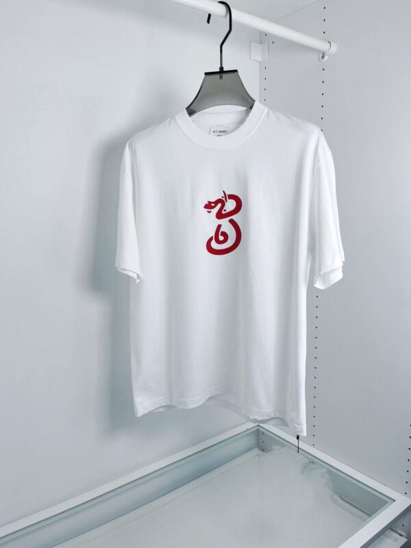 T-shirt bianca con grafica rossa artistica, stile minimalista, casual e moderna.