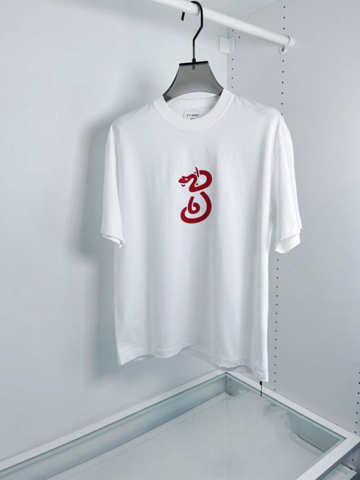 T-shirt bianca con grafica rossa artistica, stile minimalista, casual e moderna.