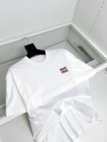 Maglietta bianca minimalista con logo rosso in vetrina, stile moderno e elegante.