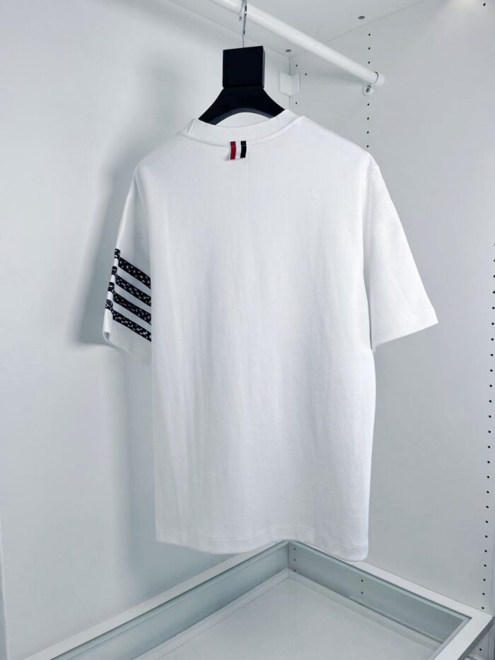 T-shirt bianco casual con strisce nere e dettaglio rosso, stile sportivo e versatile.
