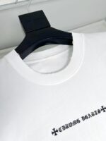 T-shirt bianco con logo diagonale “CROME DEARS” e dettagli moderni, elegante e casual.
