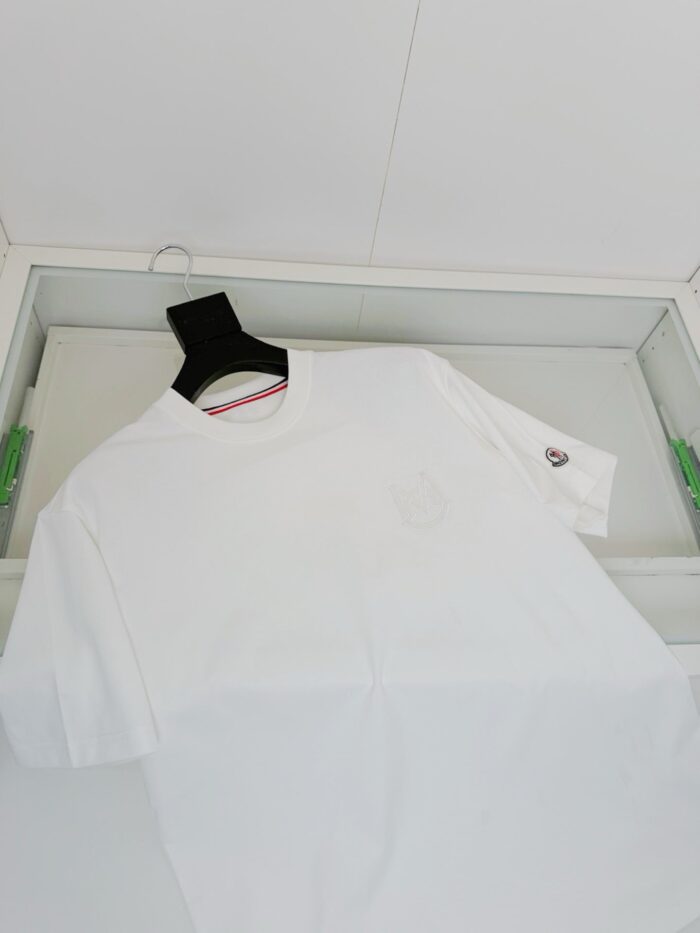 Maglietta bianca con logo e dettaglio rosso, stile casual e moderno in esposizione elegante.