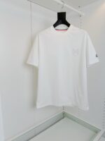 T-shirt bianca minimalista con collo rosso, logo discreto e stile casual elegante.