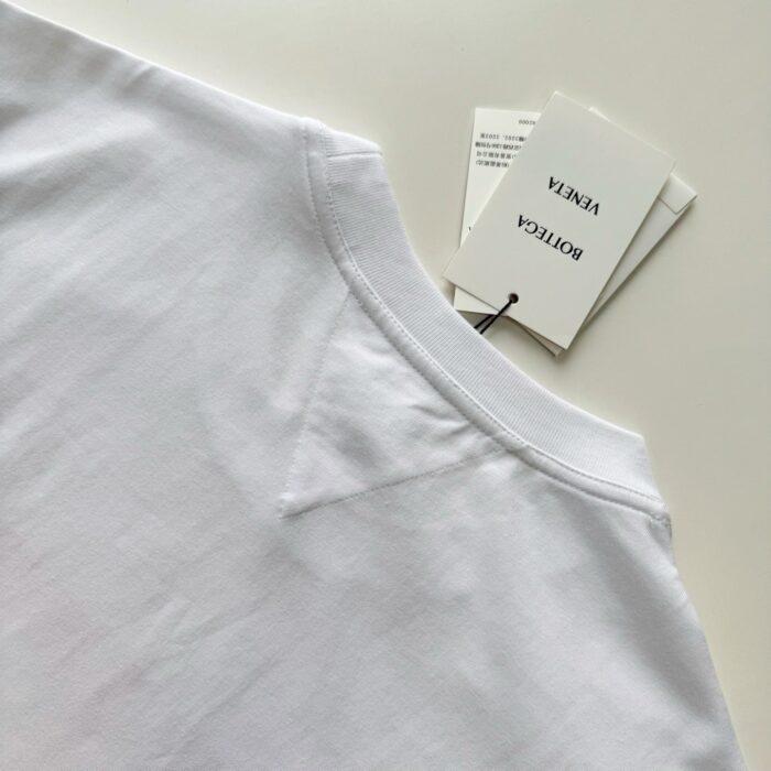 T-shirt bianco di qualità con etichetta della marca e dettagli eleganti.