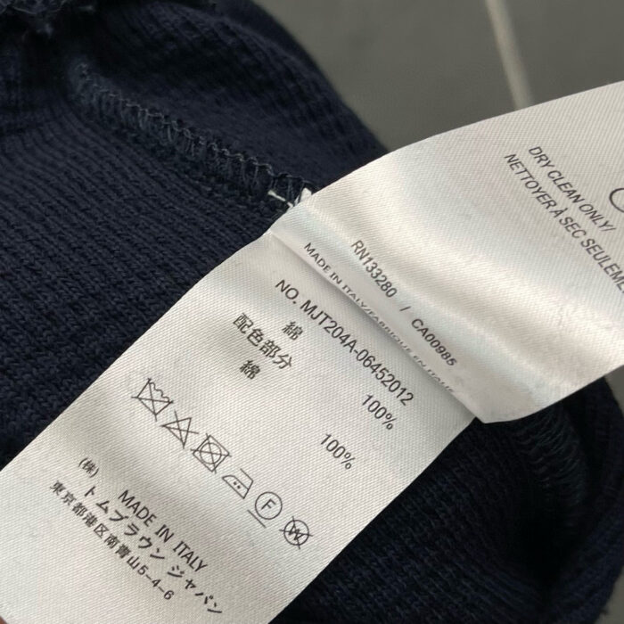 Etichetta tessuto lana, cura, Made in Italy, istruzioni di lavaggio, simboli e materiali.
