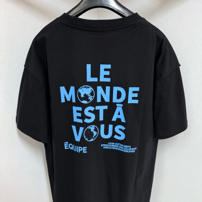 T-shirt nera con slogan Il Mondo È Tuo e grafico globale blu.