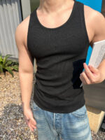 Ragazzo in estate con tank top e shorts, legge allaperto sotto il sole.