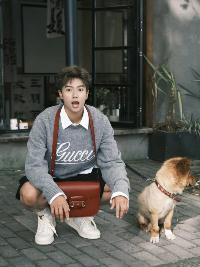 Ragazzo con cane in stile casual chic su strada con abbigliamento trendy e atmosfera vivace.