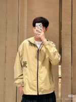 Selfie di un giovane con giacca beige e stile checkered casuale.